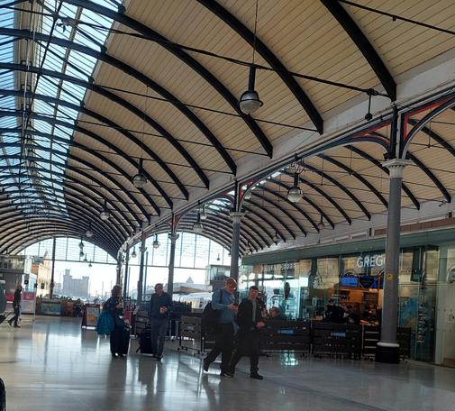 Newcastle Central Station on a sunny spring day with the castle framed in the archway.