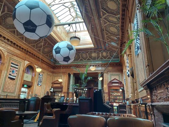 Victorian/Edwardian tiled bar in browns and greens with two huge foitballs