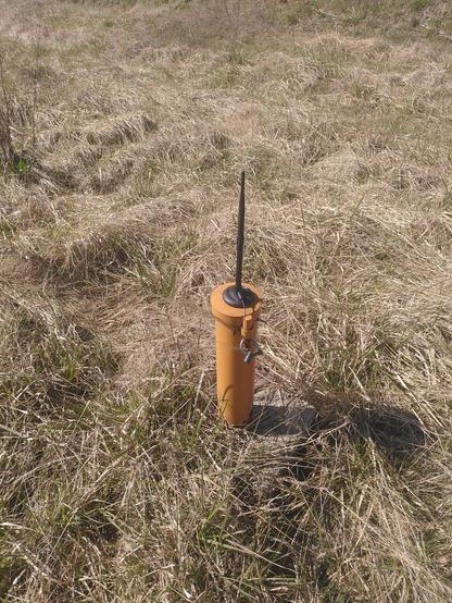 Antenne noire sur un poteau orange 