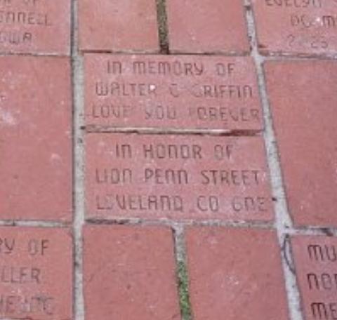 A close up photo of bricks forming a walking path. Multiple names are visible. One brick reads "In Honor of Lion Penn Street Loveland CO 6NE" 