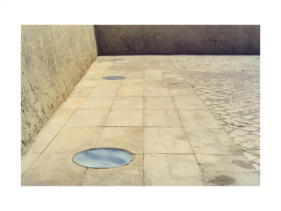 paved place in beige stone, with embedded lights, framed by walls of the same color in a darker tone