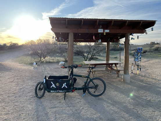 First generation racing green Larry vs harry bullitt parked under an awning with tools to repair bikes