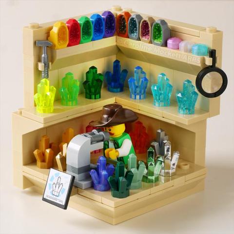 Geologist in his Minifigure Habitat surrounded by shelves full of different coloured crystals. He is examining one closely with a microscope. 