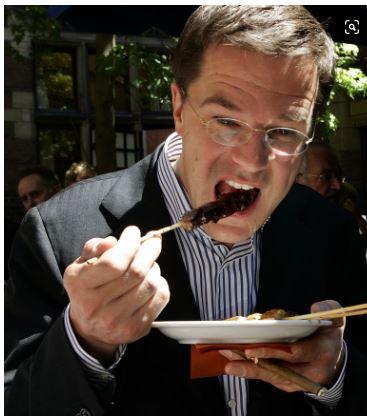 Mark Rutte eet saté tijdens de jaarlijks barbecue bij de start van het zomerreces in Den Haag. 