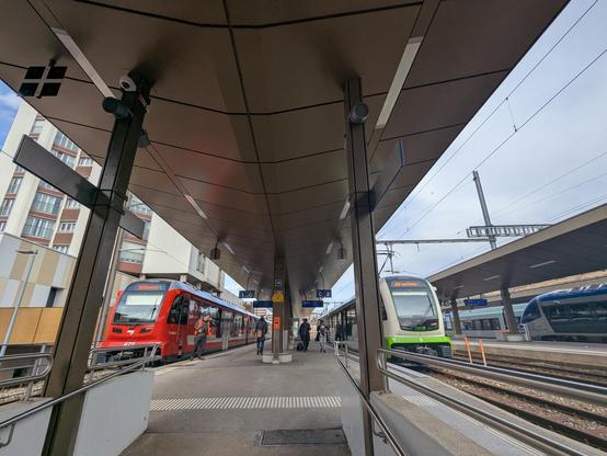 Une photo, quatre trains. Chemins de fer du Jura, transN, automotrice diesel SNCF pour Besançon et un Mika Stadler des BLS pour Berne en gare de La Chaux de Fonds