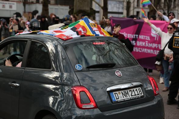 Geschmücktes Fahrzeug passiert den Gegenprotest 