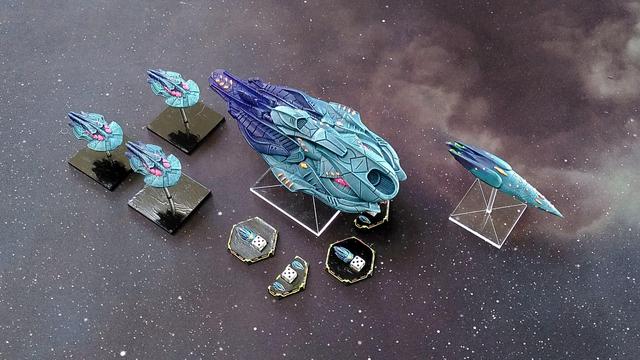5 Ships of the Aquans for Firestorm Armada. In the center a Carrier with 4 SRS Tokens. To the left 3 Escorts and to the right a Cruiser.