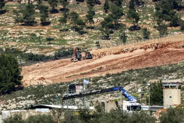 This picture taken from the village of Deir al-Hatab, east of Nablus in the occupied West Bank, on March 23, 2025, shows Israeli excavators clearing ground for expansion in the illegal settlement of Elon Moreh [Zain Jaafar/AFP]