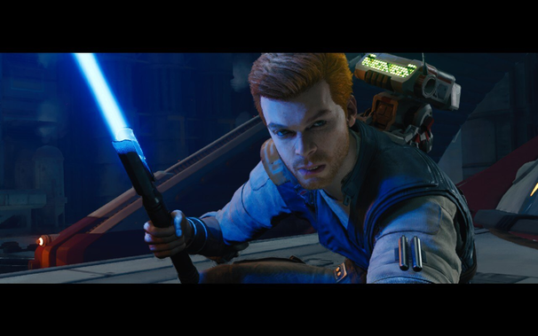 Cal Kestis looking fierce into the camera, with a lightsaber ignited in his hand.