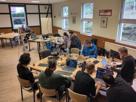 3 Tischgruppen mit Nerds bei hacken kivitendo Entwickler Sprint