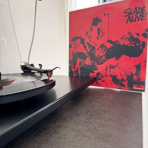 Pochette du disque "Alive" de Slade posé à côté d'une platine vinyle