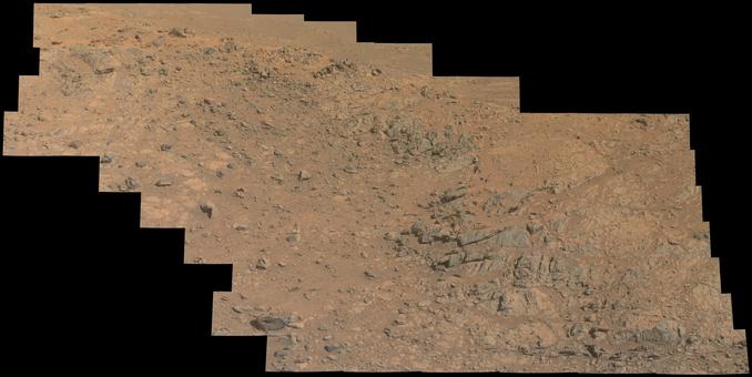 An ochre toned mosaic capturing a rocky outcrop on the slopes of the rim of Jezero crater on Mars.