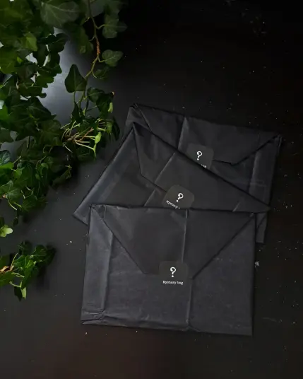 Three black envelopes made from black tissue paper. Each envelope is closed with a black sticker with a big question mark and the text Mystery bag.