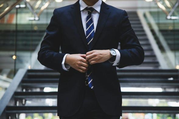 Businessman in a suit standing confidently on a staircase, looking ahead with a determined expression