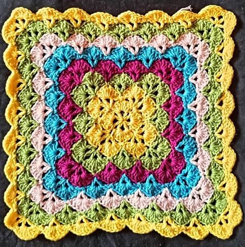 Ein buntes Quadrat im Muschelmuster gehäkelt.