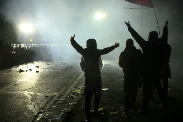 Photo Des manifestants font des gestes devant la police anti-émeute lors d'un rassemblement de soutien au maire arrêté d'Istanbul, à Istanbul, le 24 mars 2025.