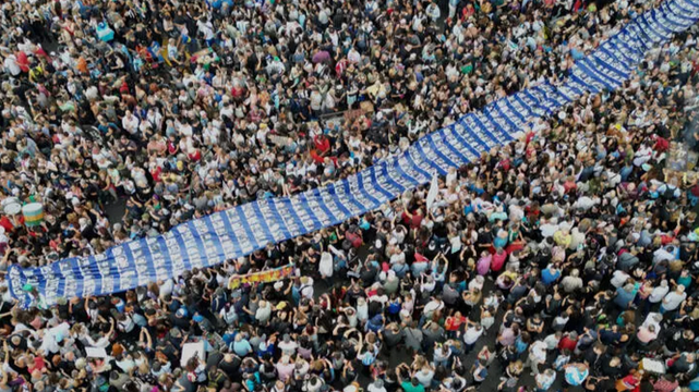  Des manifestants portent une banderole avec des photos de personnes disparues pendant la dictature militaire lors d'une marche commémorative, à Buenos Aires, le 24 mars 2025. © AP/Rodrigo Abd 