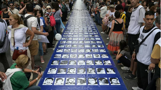 Une bannière avec des portraits de disparus pendant la dictature militaire est transportée vers la Place de Mai pour commémorer le 49e anniversaire du coup d'État, à Buenos Aires, lundi 24 mars 2025. © Juan Mabromata, AFP 