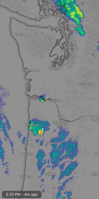 Weather radar map showing precipitation over parts of Washington and Oregon, including cities like Seattle, Portland, and Salem. Light rain is indicated in several areas, with some heavier precipitation near Tillamook.