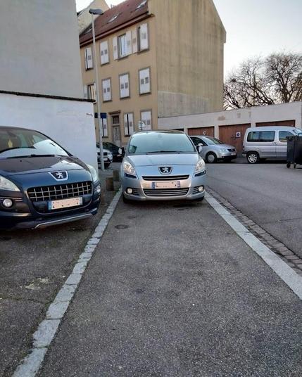 Rue Heidenberg, un Peugeot 807 gris stationné sur le trottoir, bloquant tout le passage (et la visibilité)
