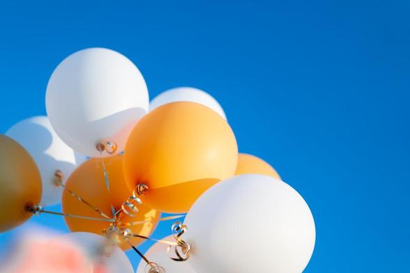 Yellow and white balloons against a blue sky. 