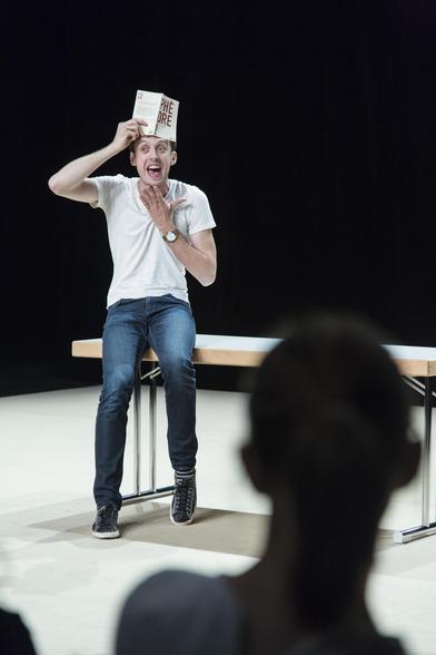 Romain Daroles joue Phèdre! mimant la courone de la Reine avec un livre sur sont front. Photo ©Loan Nguyen