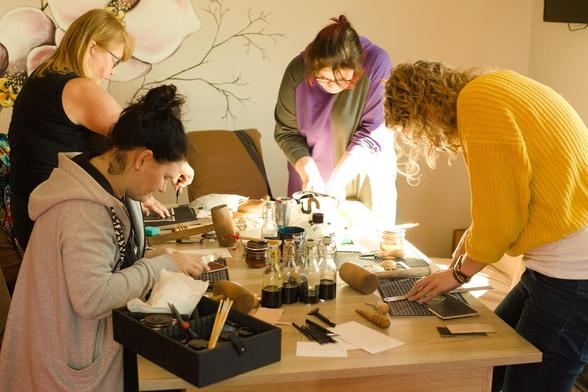 My students have gathered around the workbench and started to work on their card wallets. 