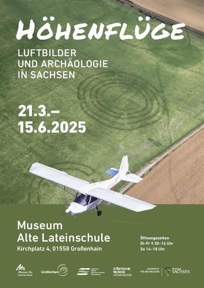 Das Poster der Wanderausstellung "Höhenflüge - Luftbilder und Archäologie in Sachsen" zeigt ein weißes Flugzeug beim Flug über ein grünes Feld mit den Kreisgrabenanlagen von Kyhna in Nordsachsen.