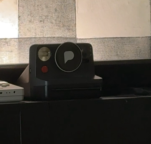 Pixelfed sticker covering the lens of a Polaroid camera
