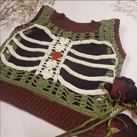 Crocheted top featuring a rib cage design in off-white, olive green, and brown yarn.