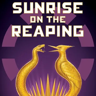 A golden pin bearing the likeness of a snake and mockingjay 