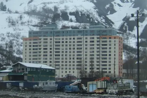 Begich is the only livable place in Whittier during winter. The building is a concrete construction from the 1950's, top is blue and the sides have red and the main part is just white which has yellowed with the years.
(Image: Unknown, Creative Commons license)