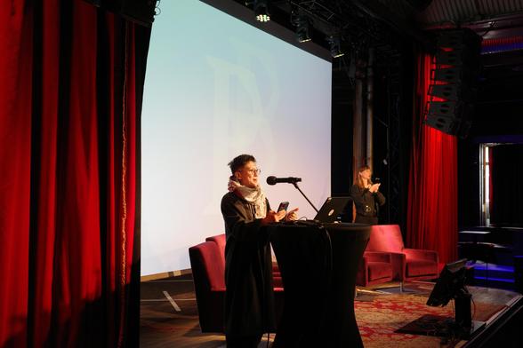 Photo of Jac sm Kee standing at a lectern, talking into a microphone.