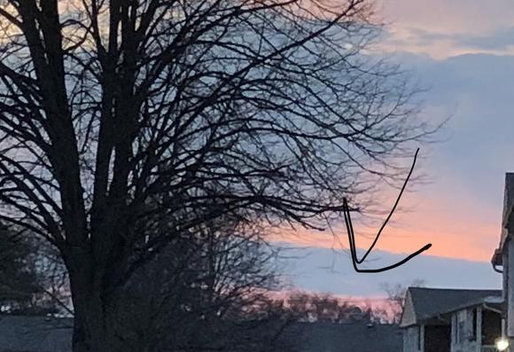 Picture of the sky with a wide band of cloud cover just where the sun would be, so I can’t see the eclipse at all. I drew an arrow to point where the sun should be.