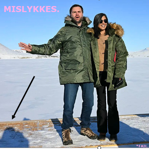 "Mislykkes
*Fail"
The Vance couple in Greenland posing for a photograph. 
A curious arrow points at something.