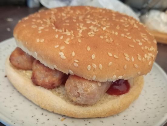 3 English Richmond sausages in a seeded burger bun with ketchup