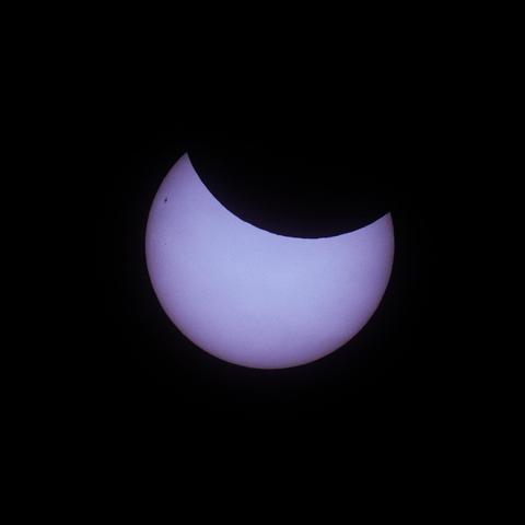 A zoomed in photo of the sun taken during the March 2025 partial solar eclipse. The background is black, the sun is a warm white, with the moon cutting a large chunk out of the top of the sun. It’s possible to make out a large sun spot on the top left of the sun and the jagged edge of the moon. Taken with an astro-modded Canon 700D camera, attached to my Skywatcher 72ED telescope with Baader solar film, on a static mount.