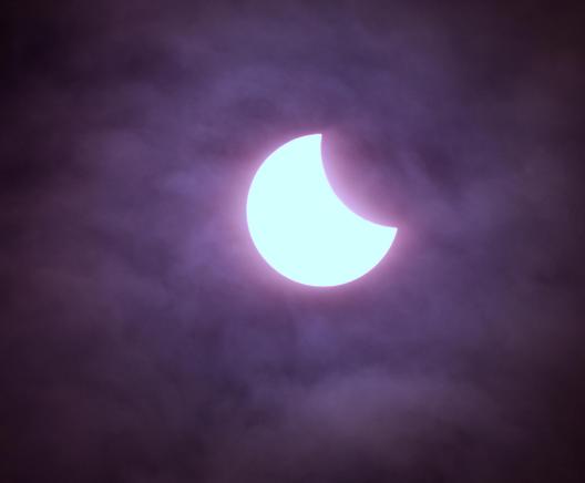 A zoomed in photo of the sun taken during the March 2025 partial solar eclipse. An ‘arty’ shot, the sun with the moon just cutting into the top right, is just visible though the clouds. Taken with an astro-modded Canon 700D camera, attached to my Skywatcher 72ED telescope with Baader solar film, on a static mount.