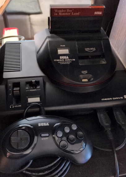Mega Drive console and controller, Power Base Converter with Wonder Boy in Monster Land Master System game attached.