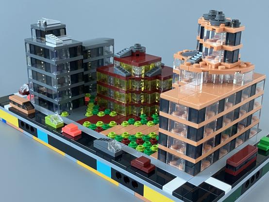 Front right three quarter view showing a smaller dark red building with trans yellow windows in the middle, and a nougat, trans clear and trans black block on the right hand side. 