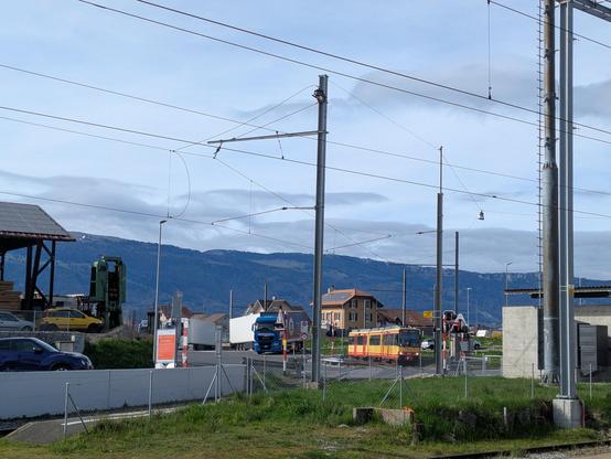 Un train jaune et rouge de Travys en courbe en entrant en gare de Chavornay en provenance d'Orbe.