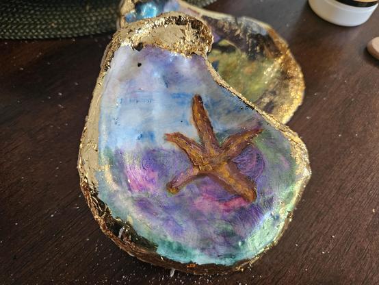 Painting of a starfish setting on a colorful ocean floor.