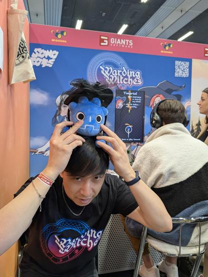 Game called Warding Witches, Godot plush wearing a witch hat on top of the developers head
