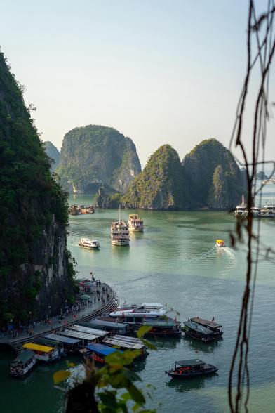 Barcos amarrados y navegando con las montañas típicas de la Bahia de Ha Long.