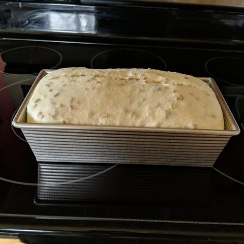 A loaf of bread that has risen in a bread pan. The center has been cut, sliced, razored, whatever the actual word is...