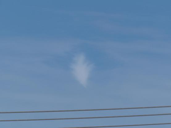 A roughly conical puff of whitish cloud, pointing downward, with a clearer gap separating it from a normal looking layer of gray cloud which is thin enough to see blue sky through