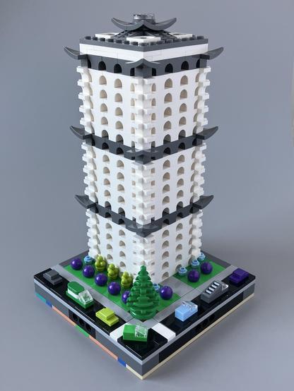 An 18-storey tower block built with white arch bricks with three dark grey bands at equal intervals up the structure
