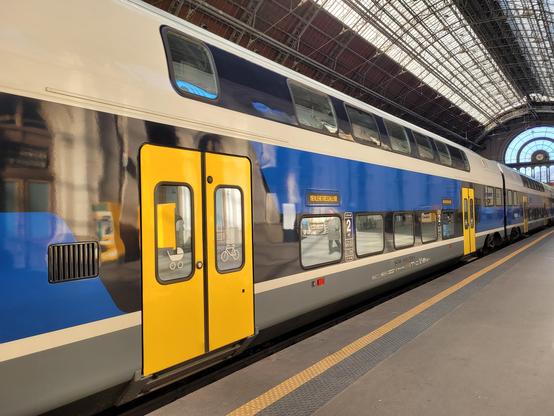 Modern double-decker EMU regional train (Stadler) with bicycle & stroller logo, on most carriages.