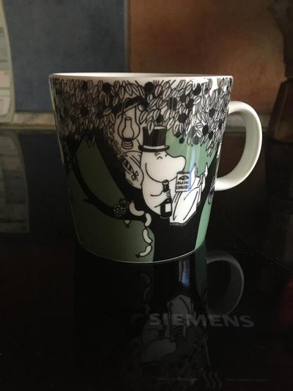 Mumin with a top hat holding a bottle of wine and chilling in a tree