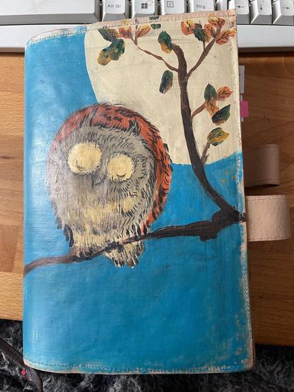 Little owl on a branch with some leaves, behind it the full moon and a dark turquoise sky. Attempt to copy Hiroshiges owl on my planner cover